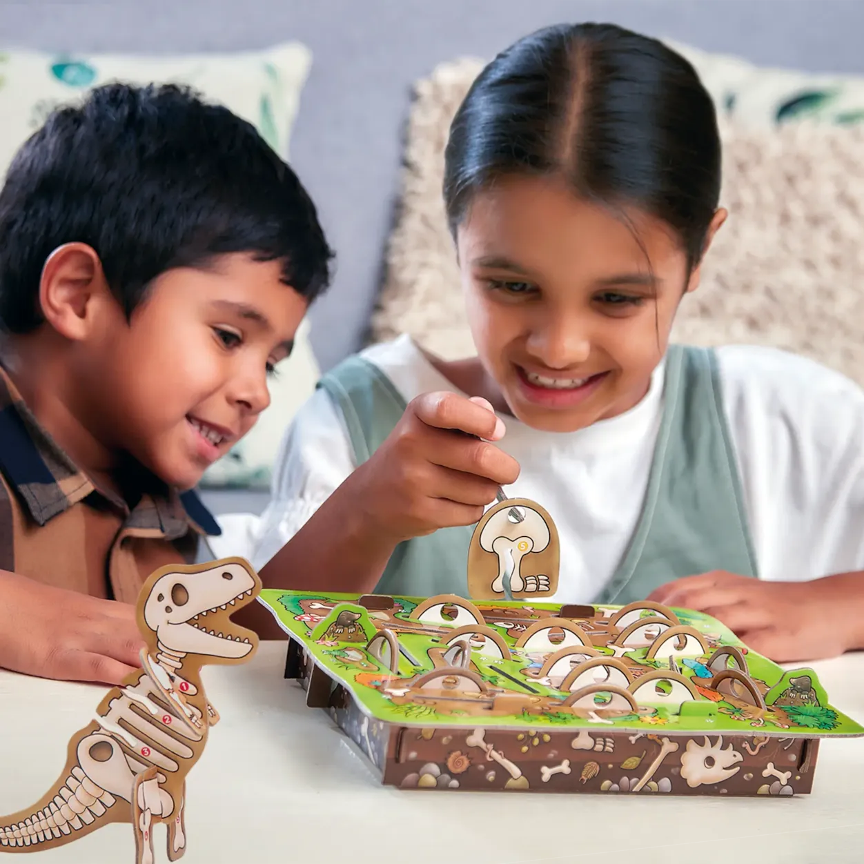 Two children playing with a dinosaur-themed board game