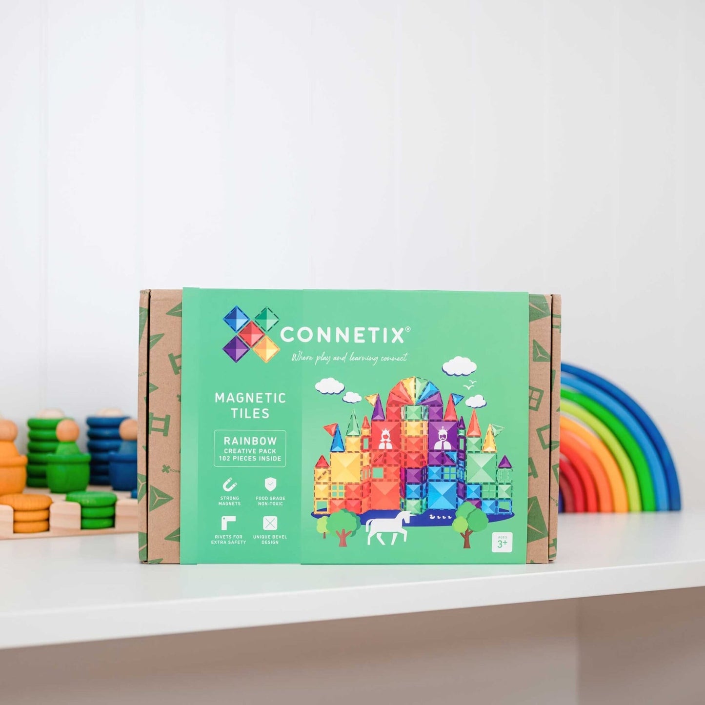 Connetix magnetic tiles packaging with colorful toy elements in the background