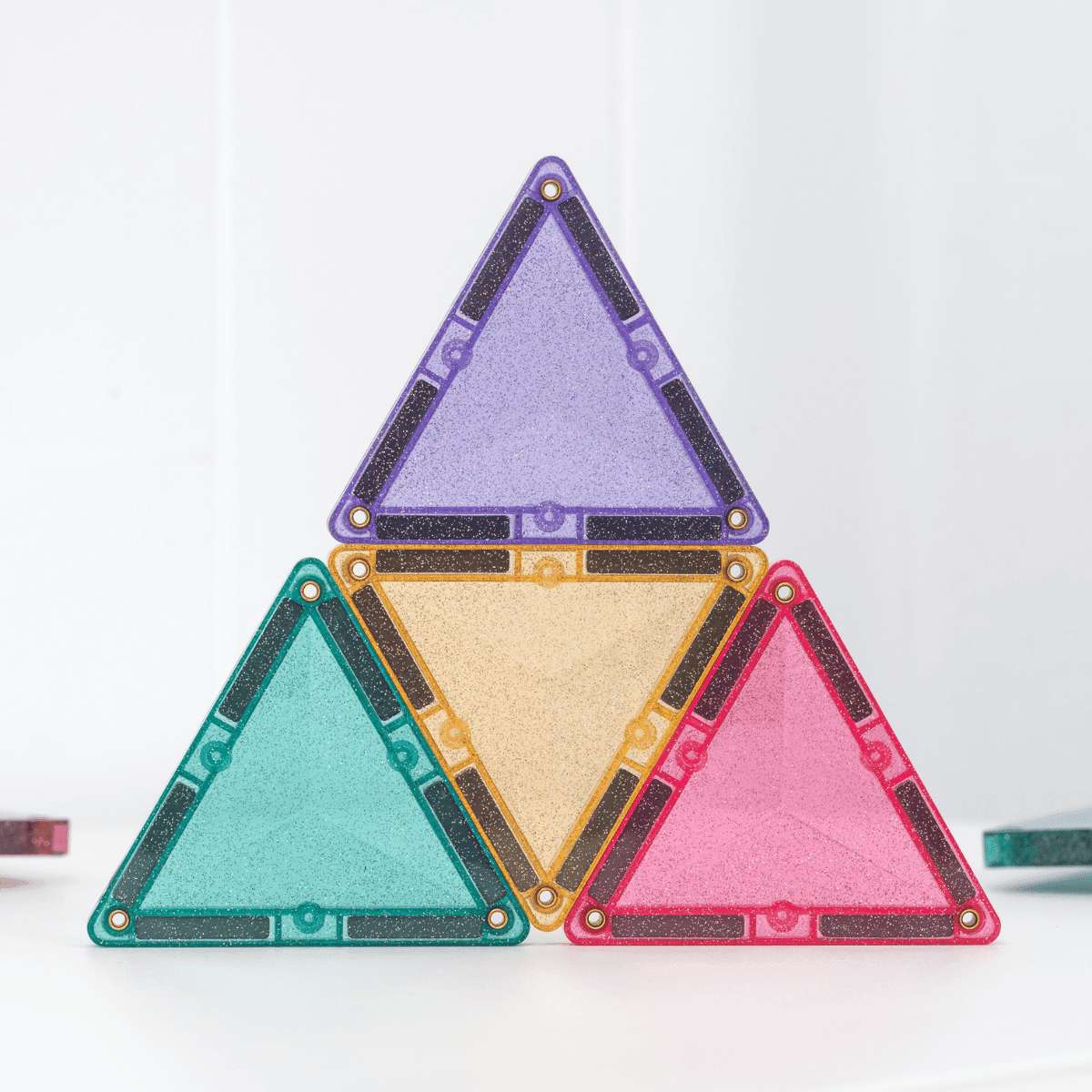 Four triangular tiles in purple, green, gold, and pink on a white background