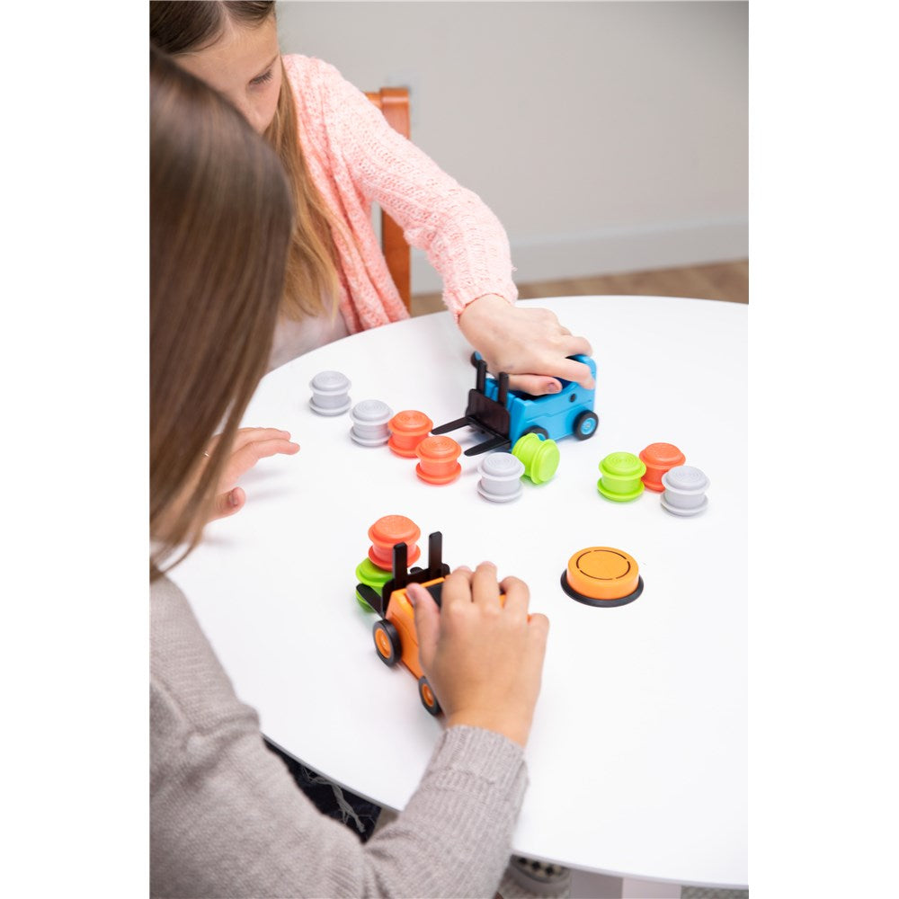 Two children playing with colorful toy cars on a white table.