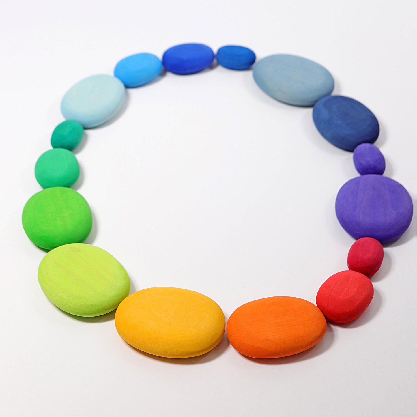 Colourful wooden pebbles on white background