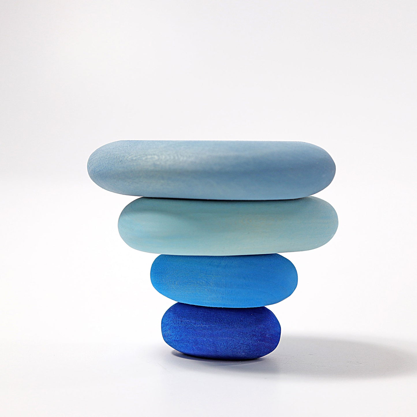 Stack of four blue stones on a white background