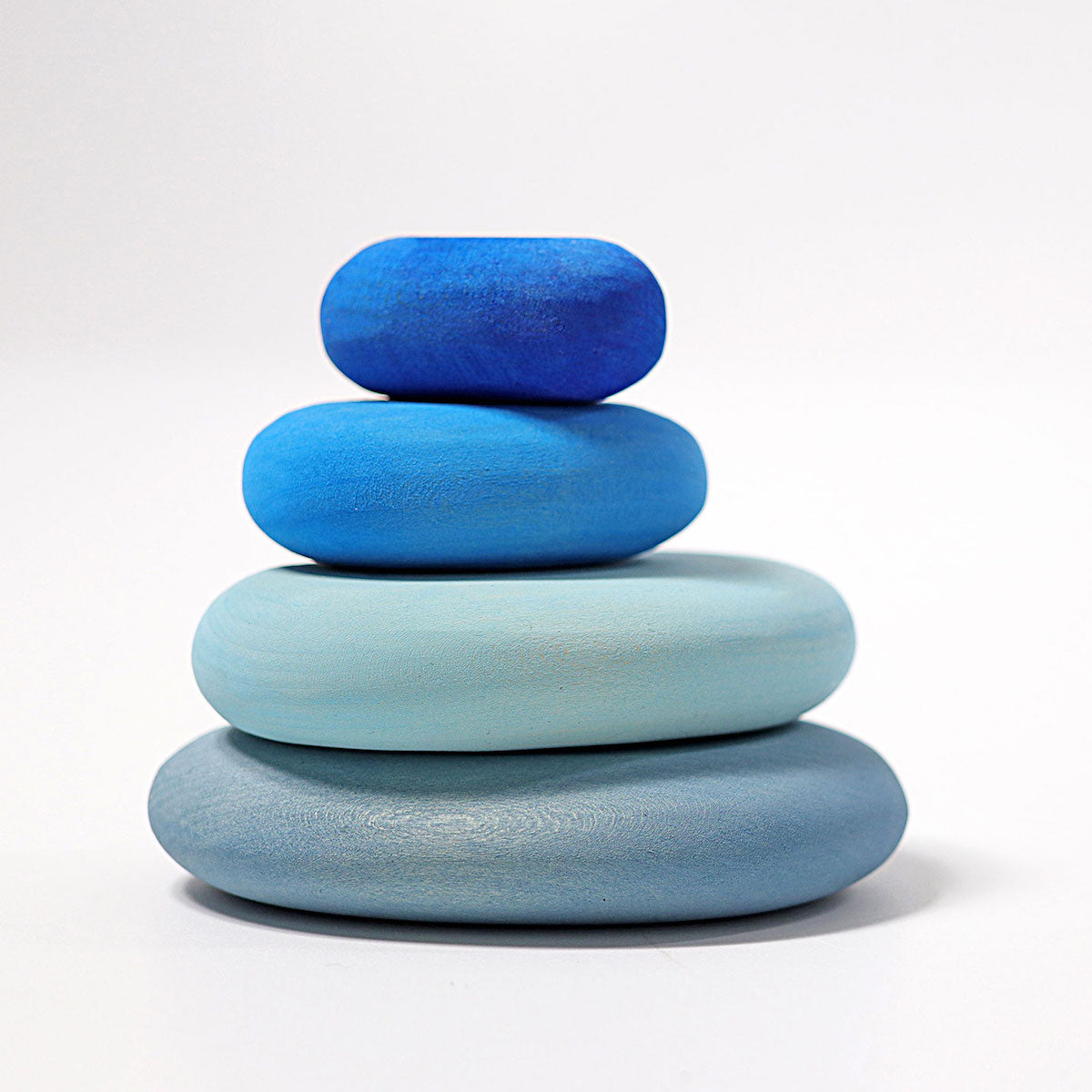 Stack of four blue stones on a white background