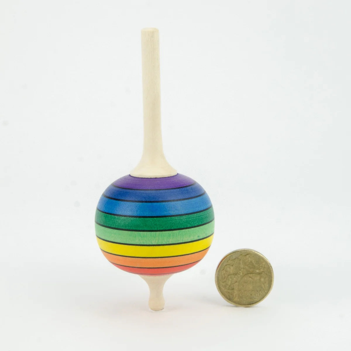 Colorful striped wooden top with a coin for scale on a white background