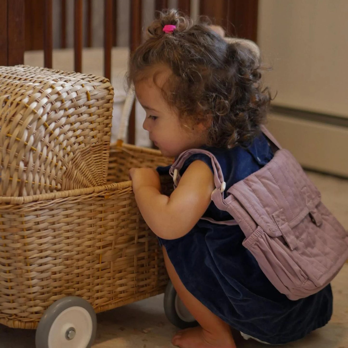 Child playing with a wicker toy chest in a home setting