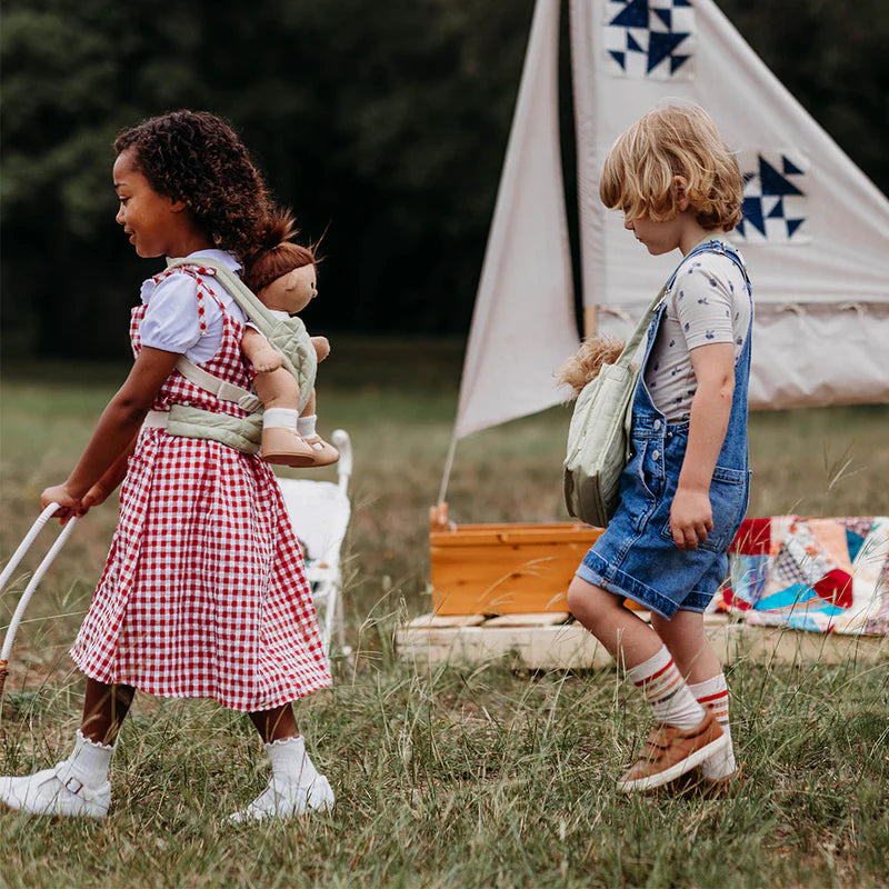 Two children playing outdoors with a tent and toys in the background