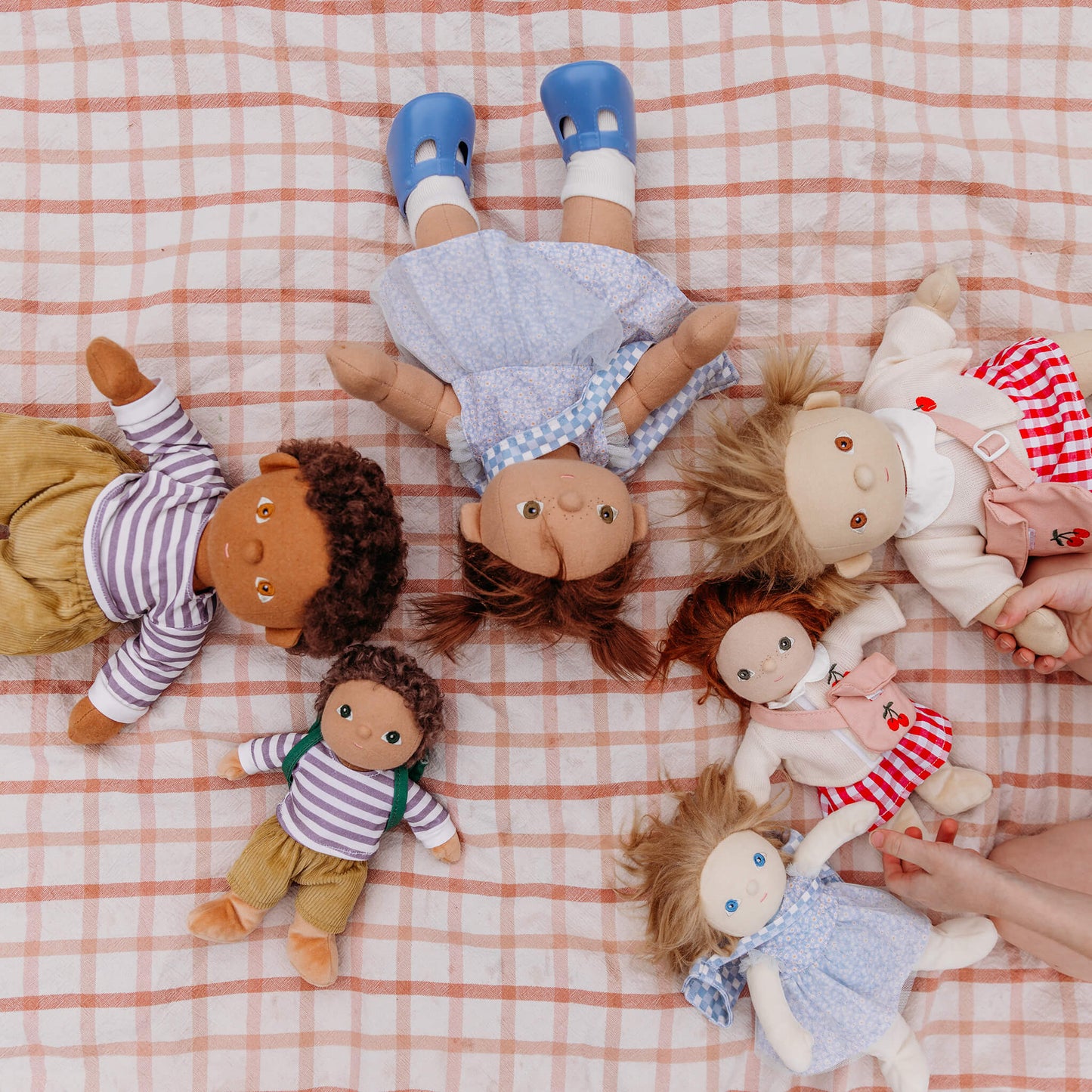 Collection of dolls on a checkered fabric surface