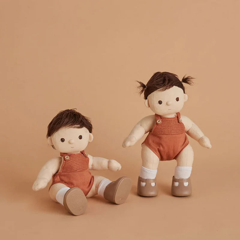 Two dolls in matching outfits on a beige background