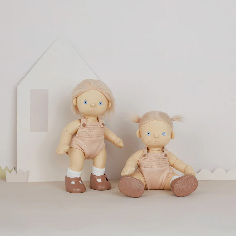 Two dolls in beige outfits with polka dot shoes on a light background