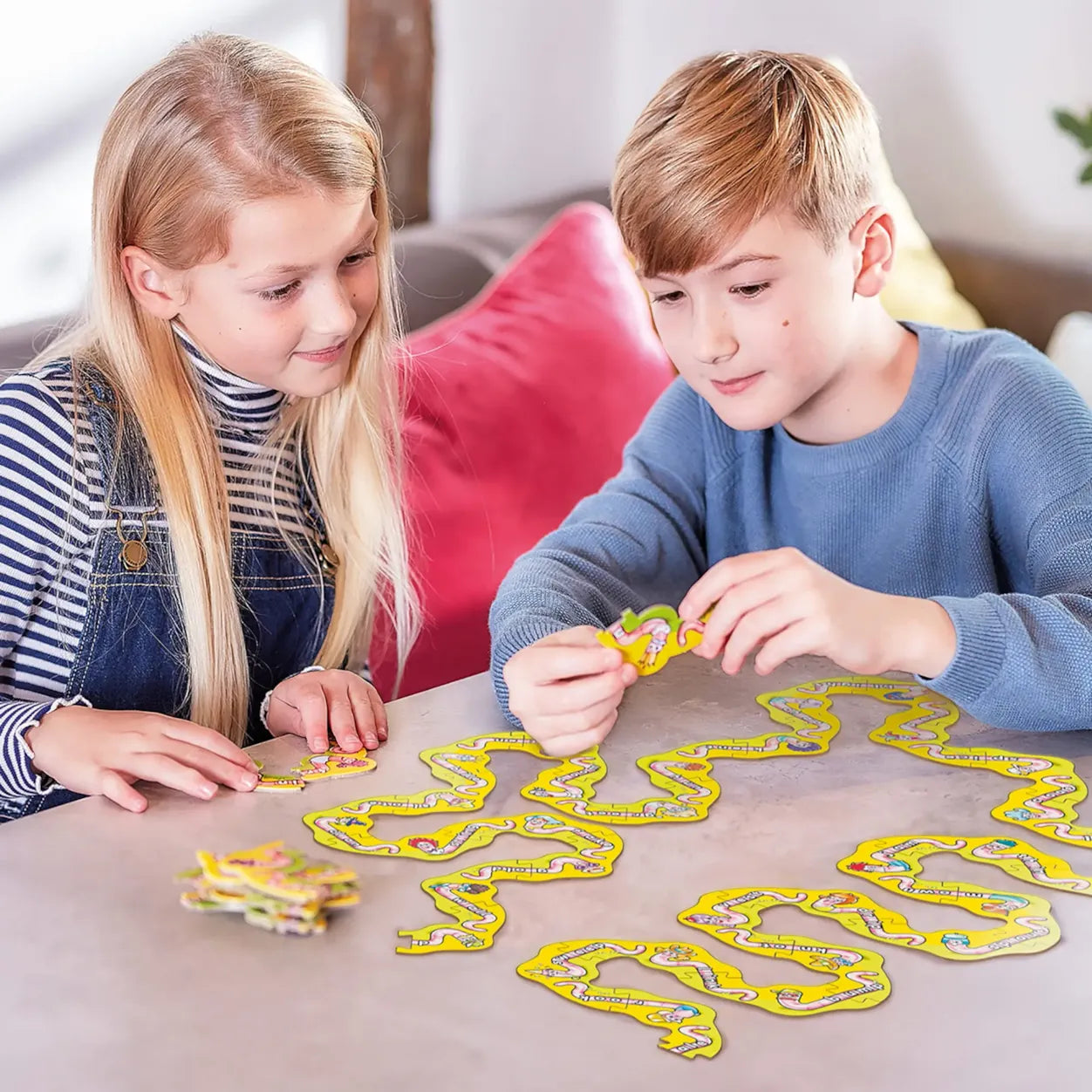 Two children playing with a board game on a table.