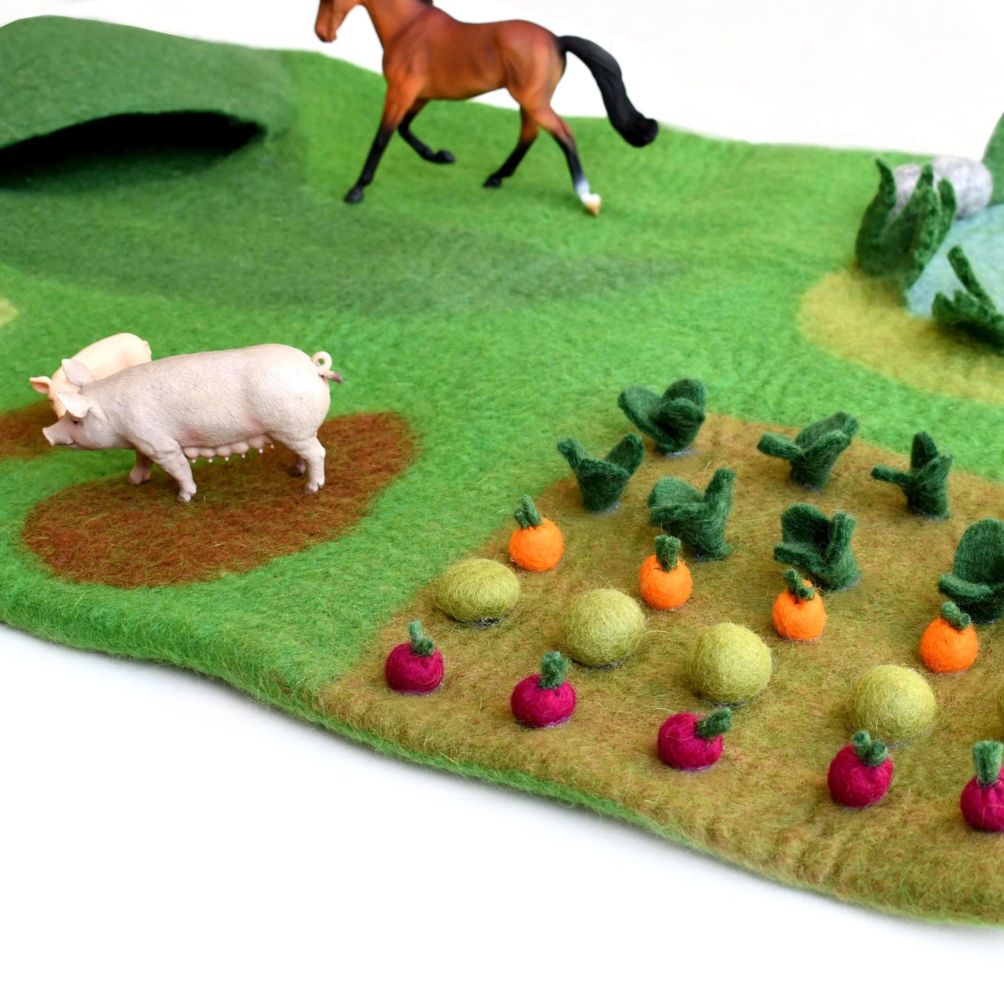 Felt play mat with farm animals and vegetables on a white background