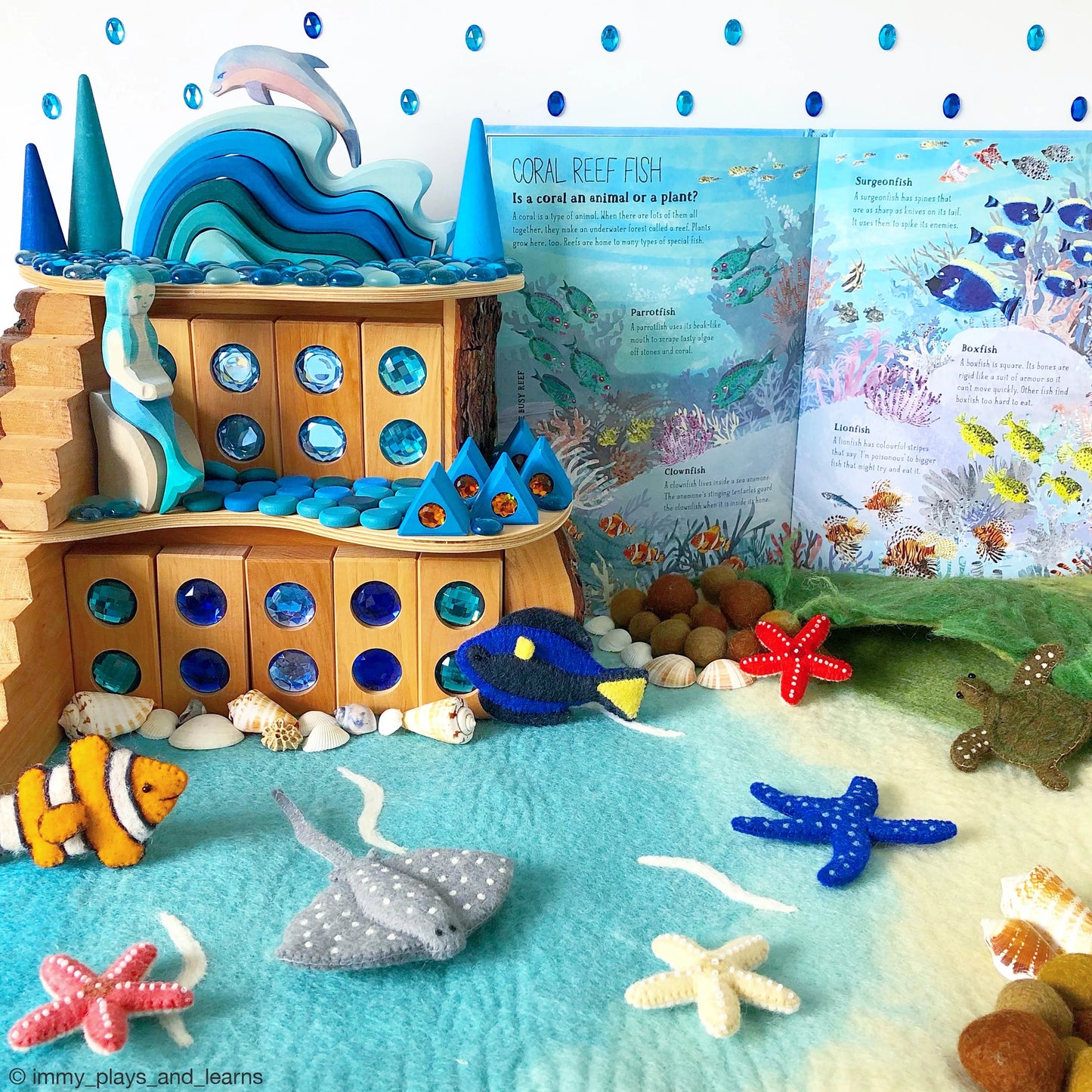 Toy coral reef set with fish and underwater decorations, including a book on the side.