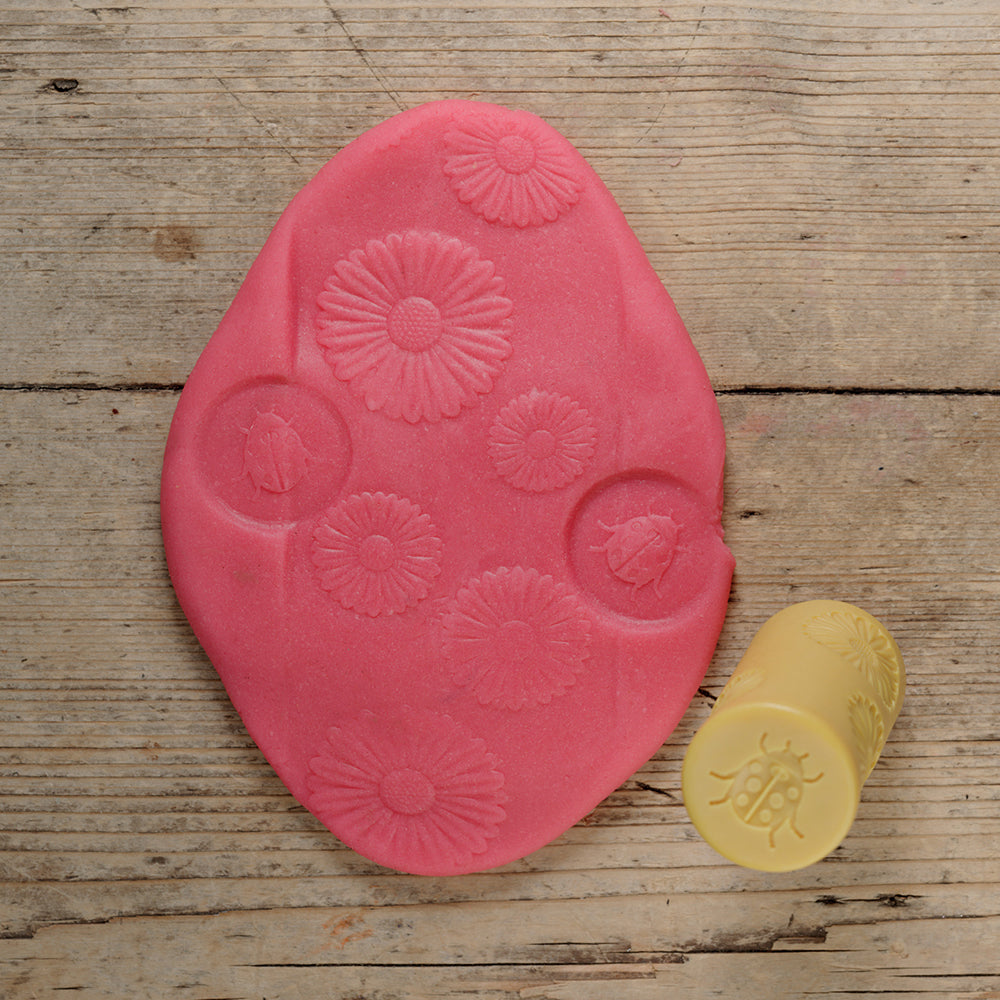 Pink silicone mold with floral designs on a wooden surface