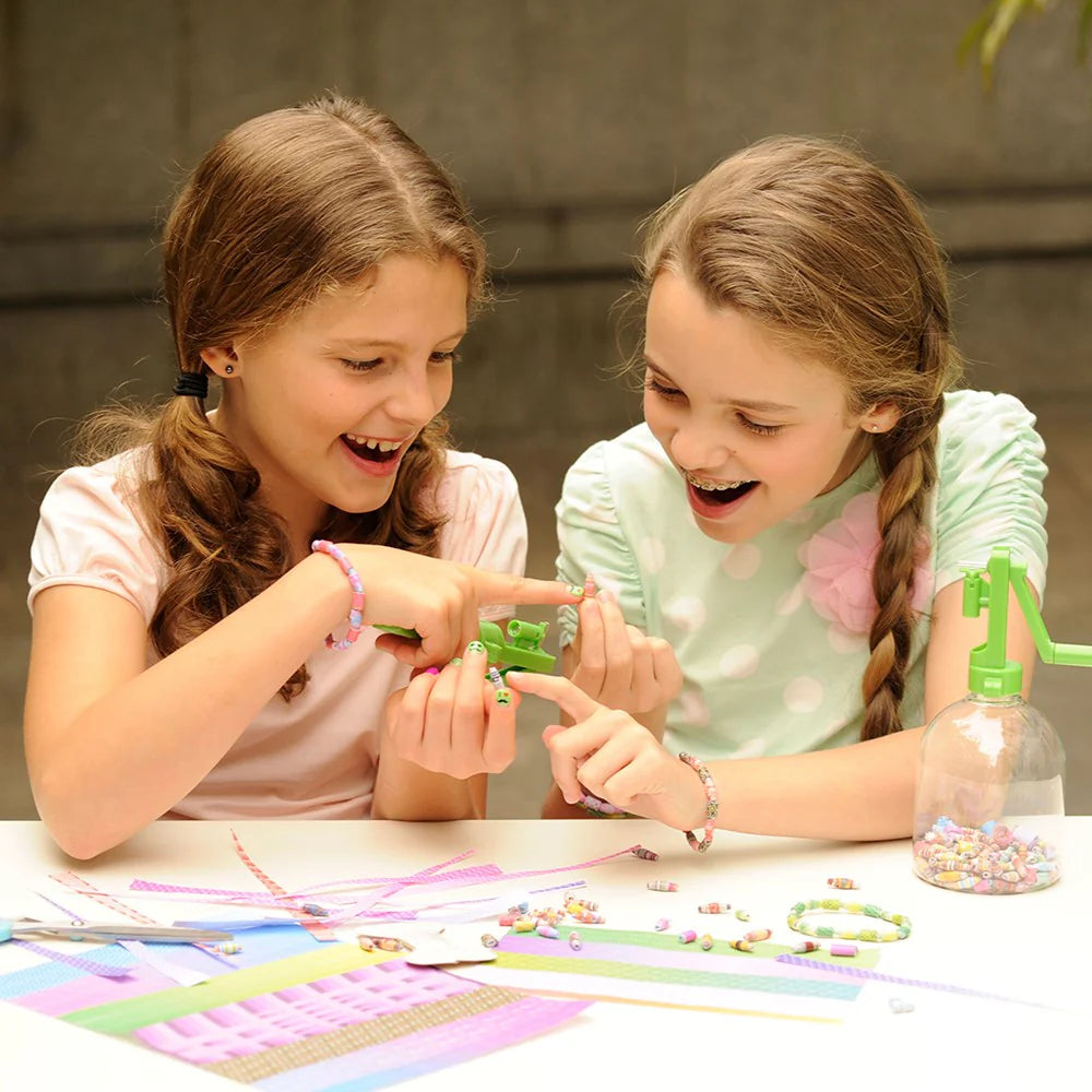 Two young girls playing with colorful toys at a table.
