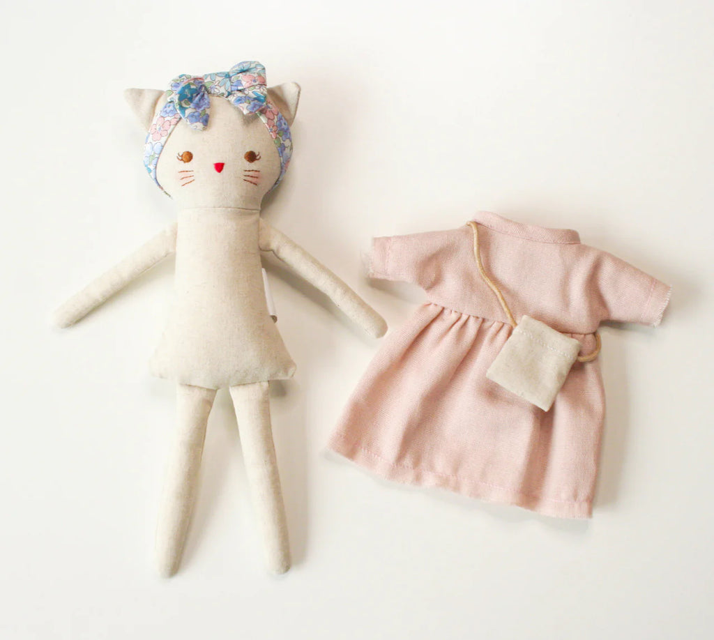 Stuffed animal with a floral headband and a pink dress on a white background