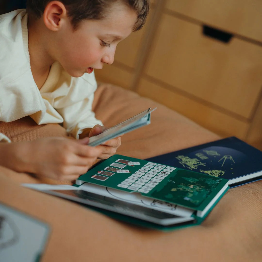 Child reading a book on a wooden surface