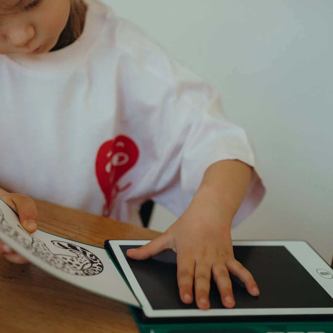 Child interacting with a digital tablet on a wooden surface