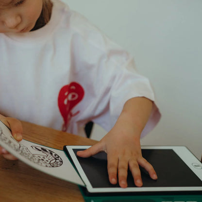 Child interacting with a digital tablet on a wooden surface