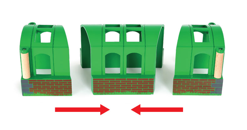 Three green plastic toy buildings with red arrows indicating direction on a white background
