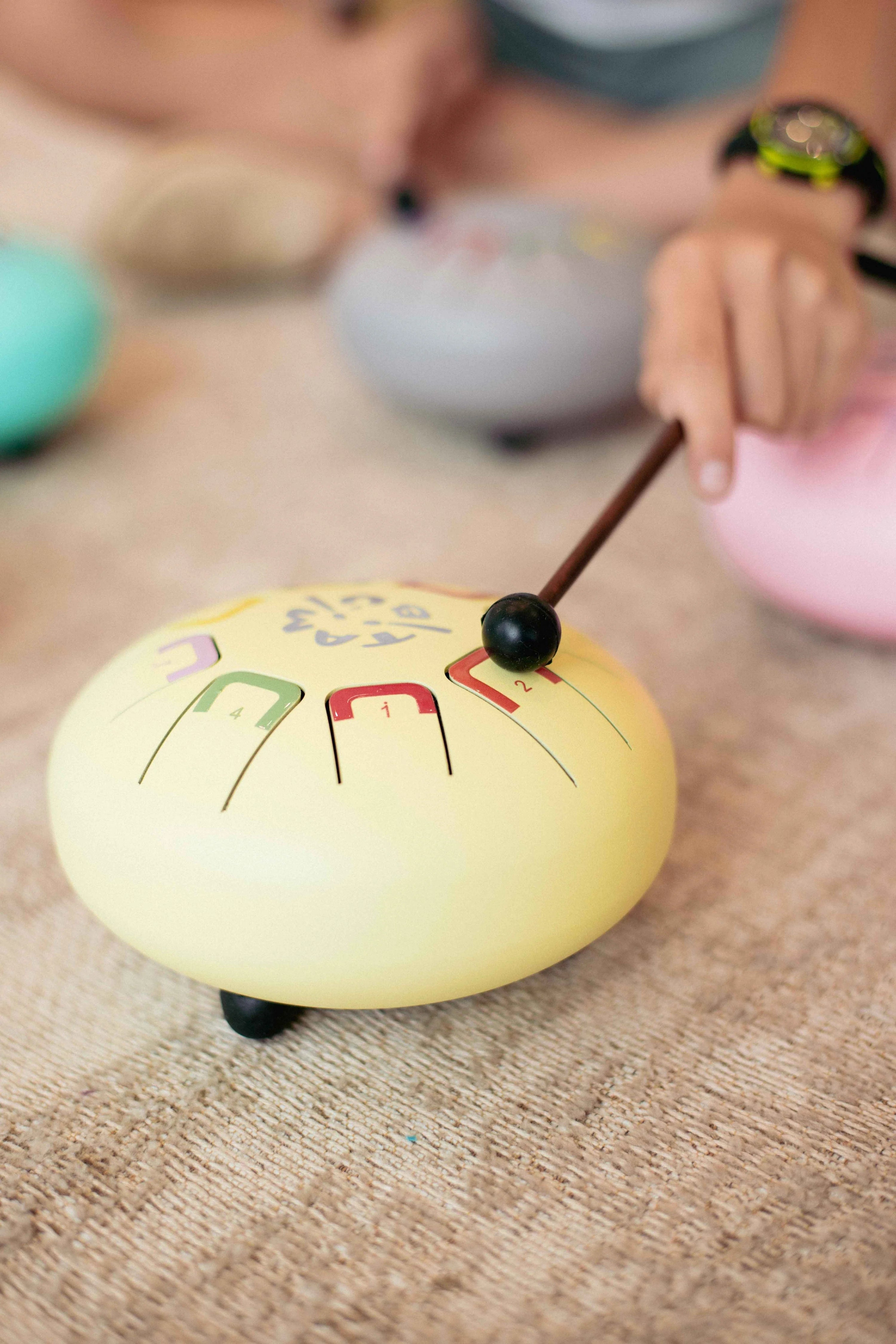 Yellow gong with black handle on a wooden surface