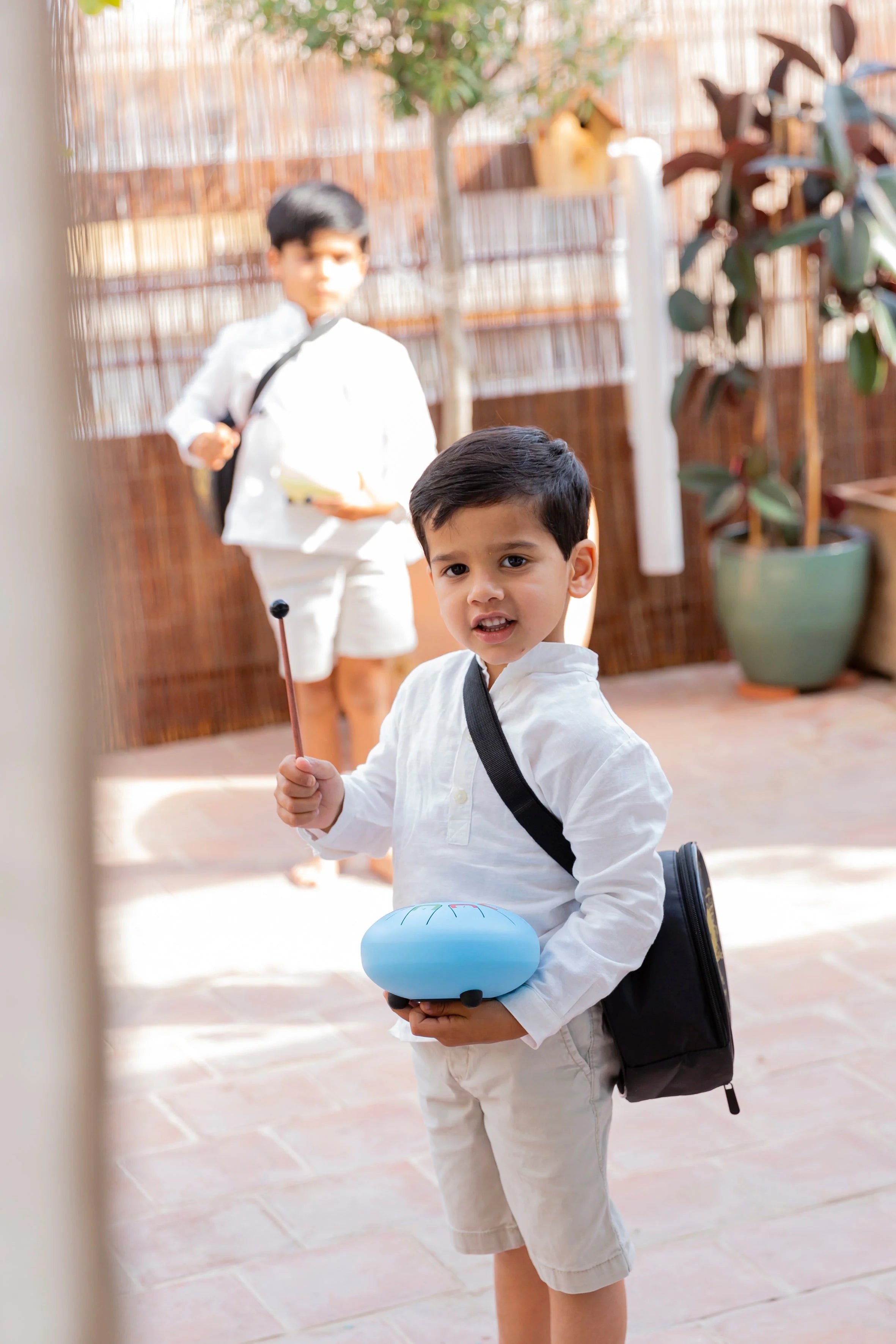 Child with a backpack and blue object in an outdoor setting