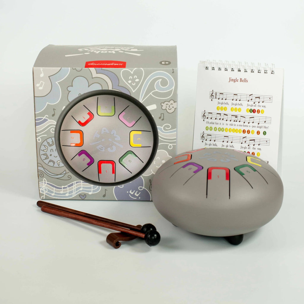 Educational musical instrument set with drum, rhythm chart, and music sheet on a white background