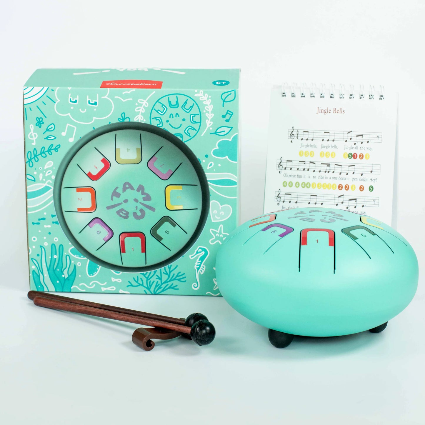 Turquoise children's musical instrument set with packaging and sheet music on a light blue background