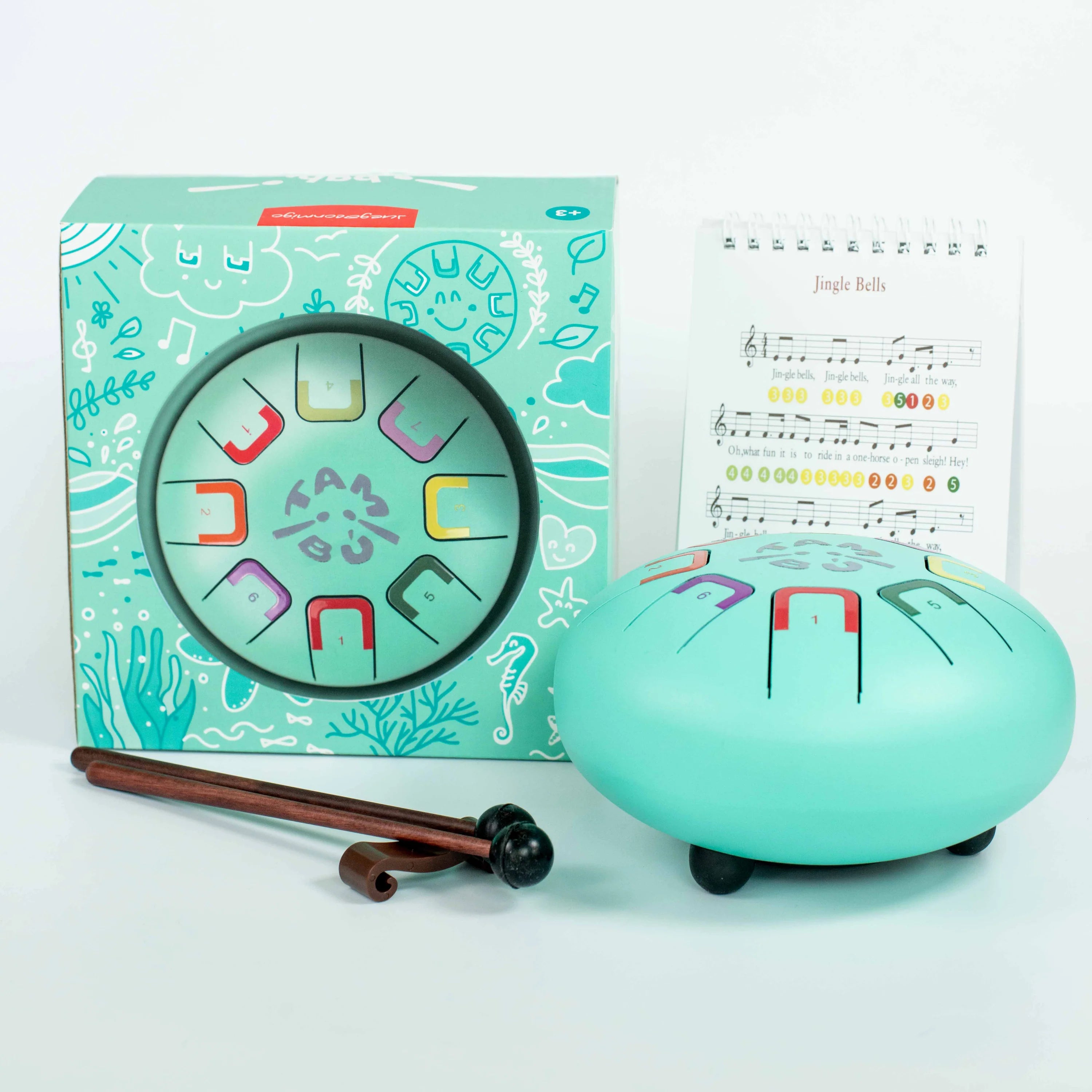 Turquoise children's musical instrument set with packaging and sheet music on a light blue background