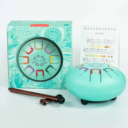 Turquoise children's musical instrument set with packaging and sheet music on a light blue background