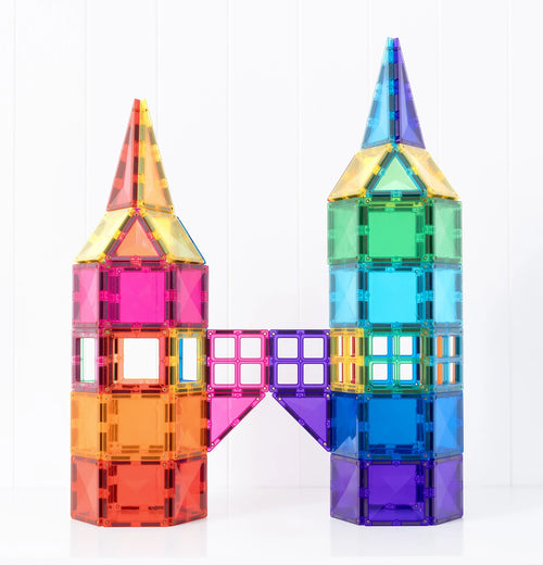 Two colorful transparent magnetic building towers connected by a matching bridge, made from translucent rainbow tiles on a white background.