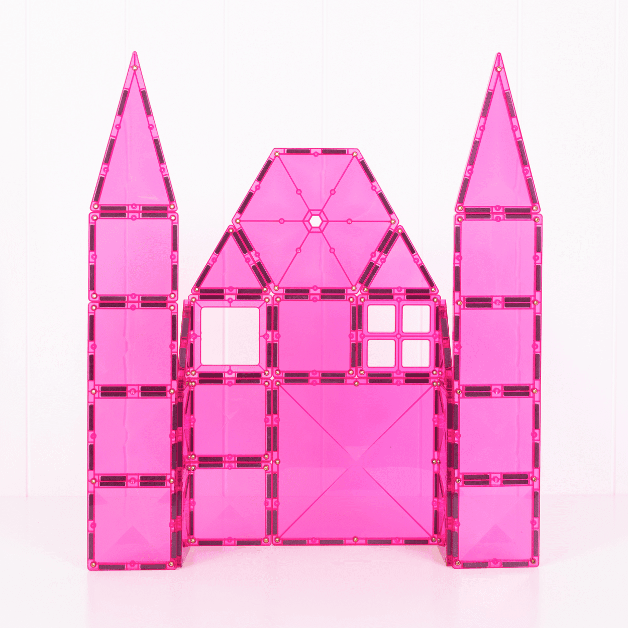Pink toy castle with two tall towers on a white background