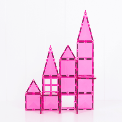 Pink toy castle made of interlocking bricks on a white background