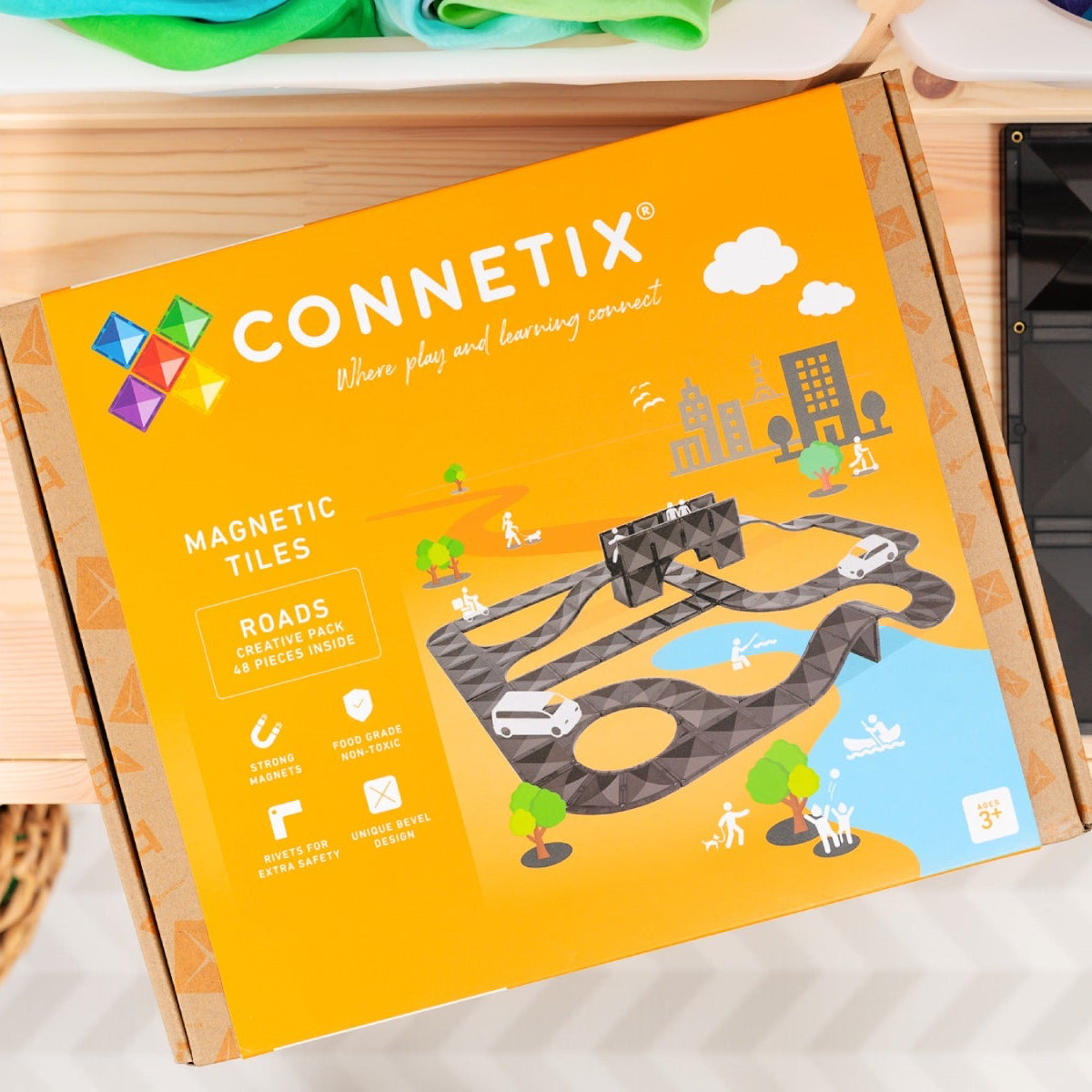 Connetix magnetic tiles packaging with colorful magnetic tiles on a wooden surface