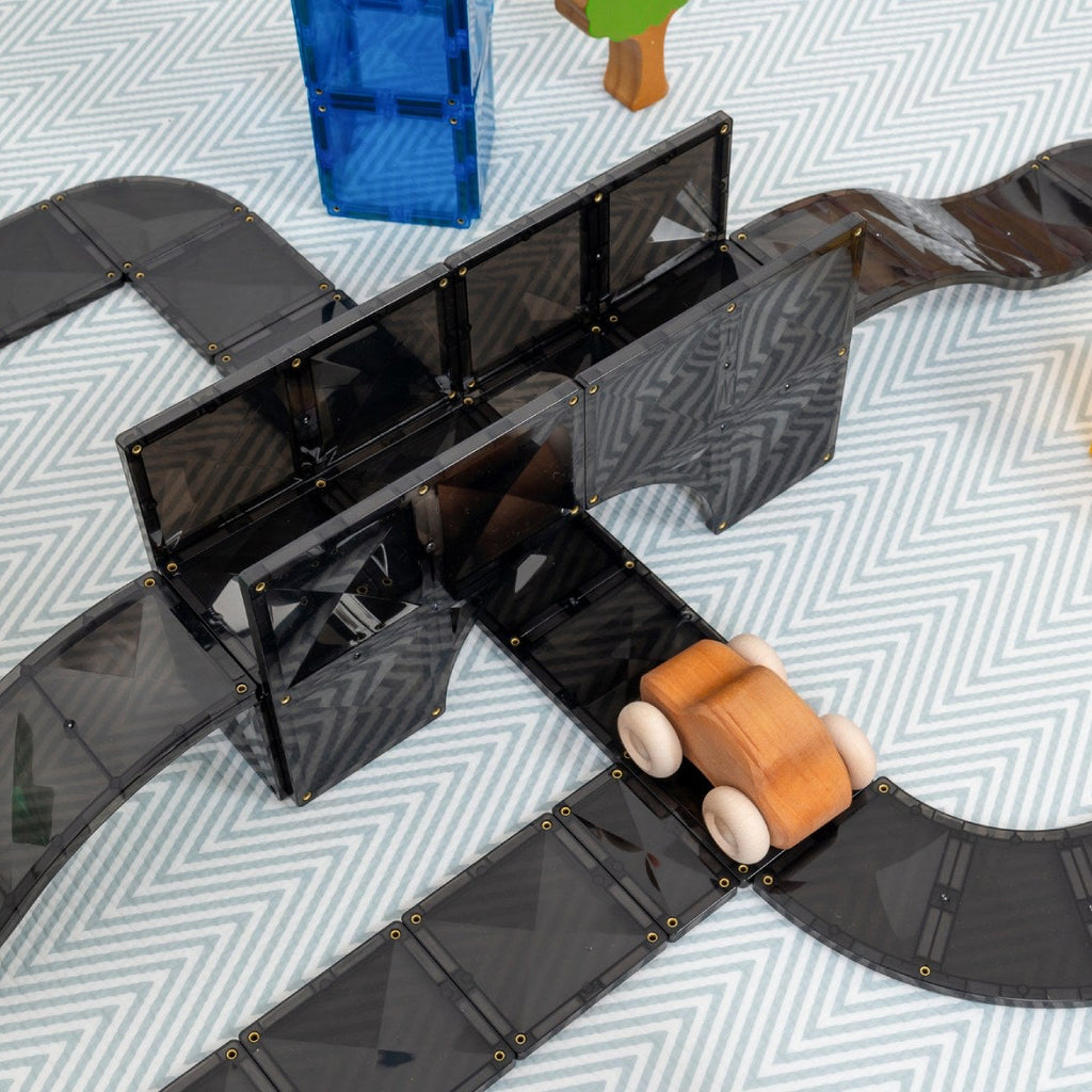 Toy track set with wooden cars on a patterned surface