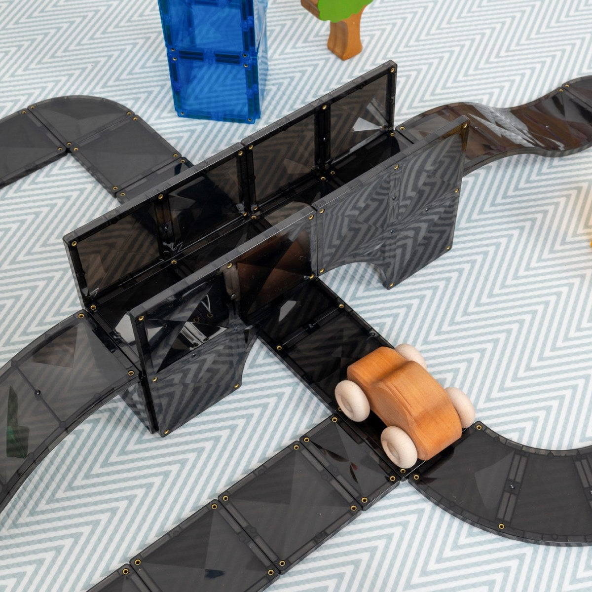 Toy track set with wooden cars on a patterned surface