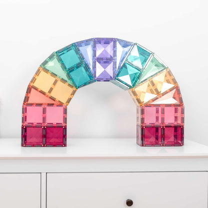 Colorful arch-shaped structure made of interlocking tiles on a white surface.