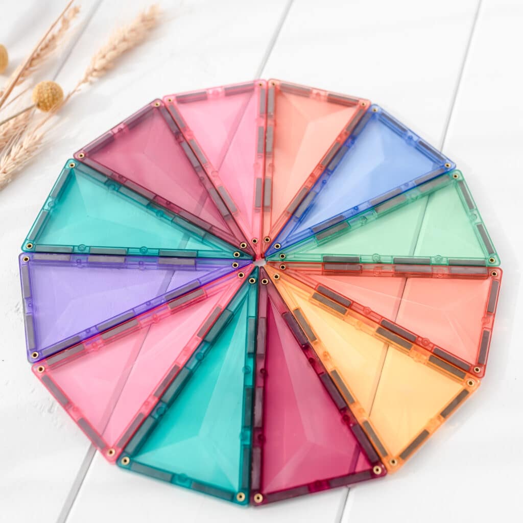 Colorful geometric plastic pieces arranged in a circular pattern on a light background.