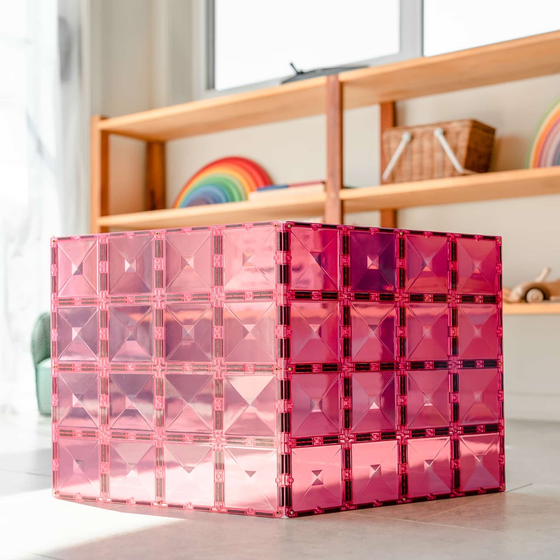 Pink transparent geometric tiles on a surface with a blurred background