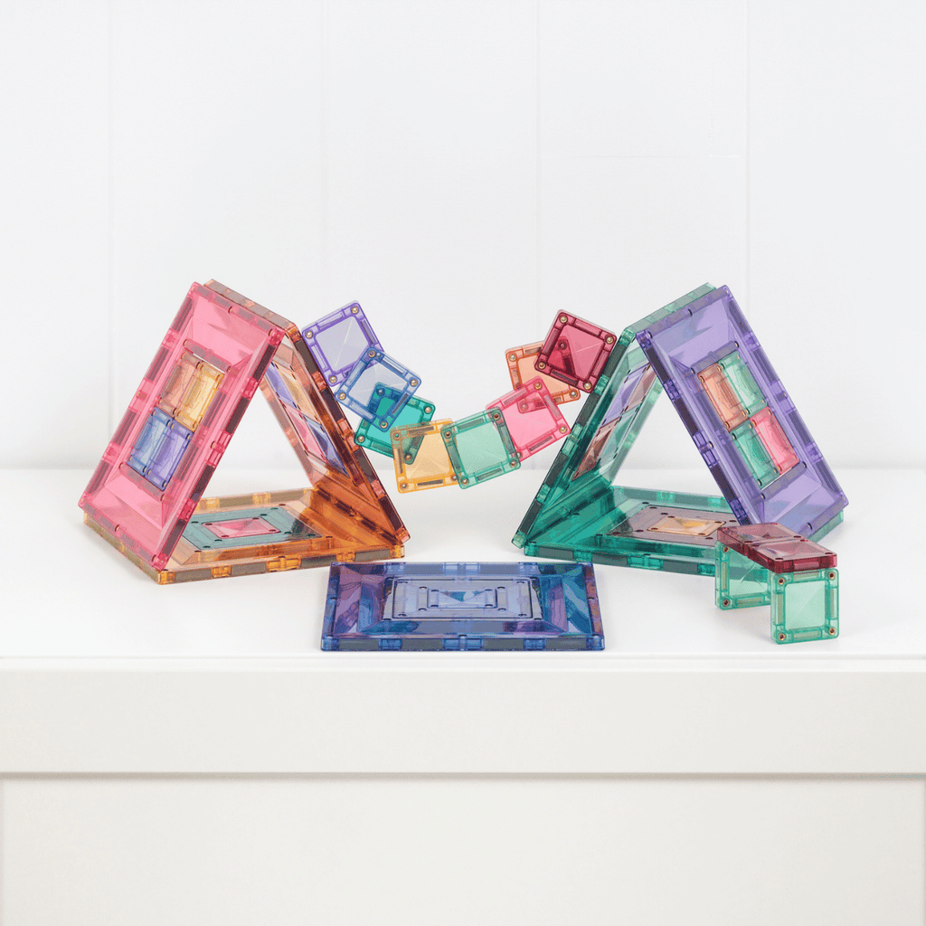 Colorful transparent geometric building blocks on a white surface