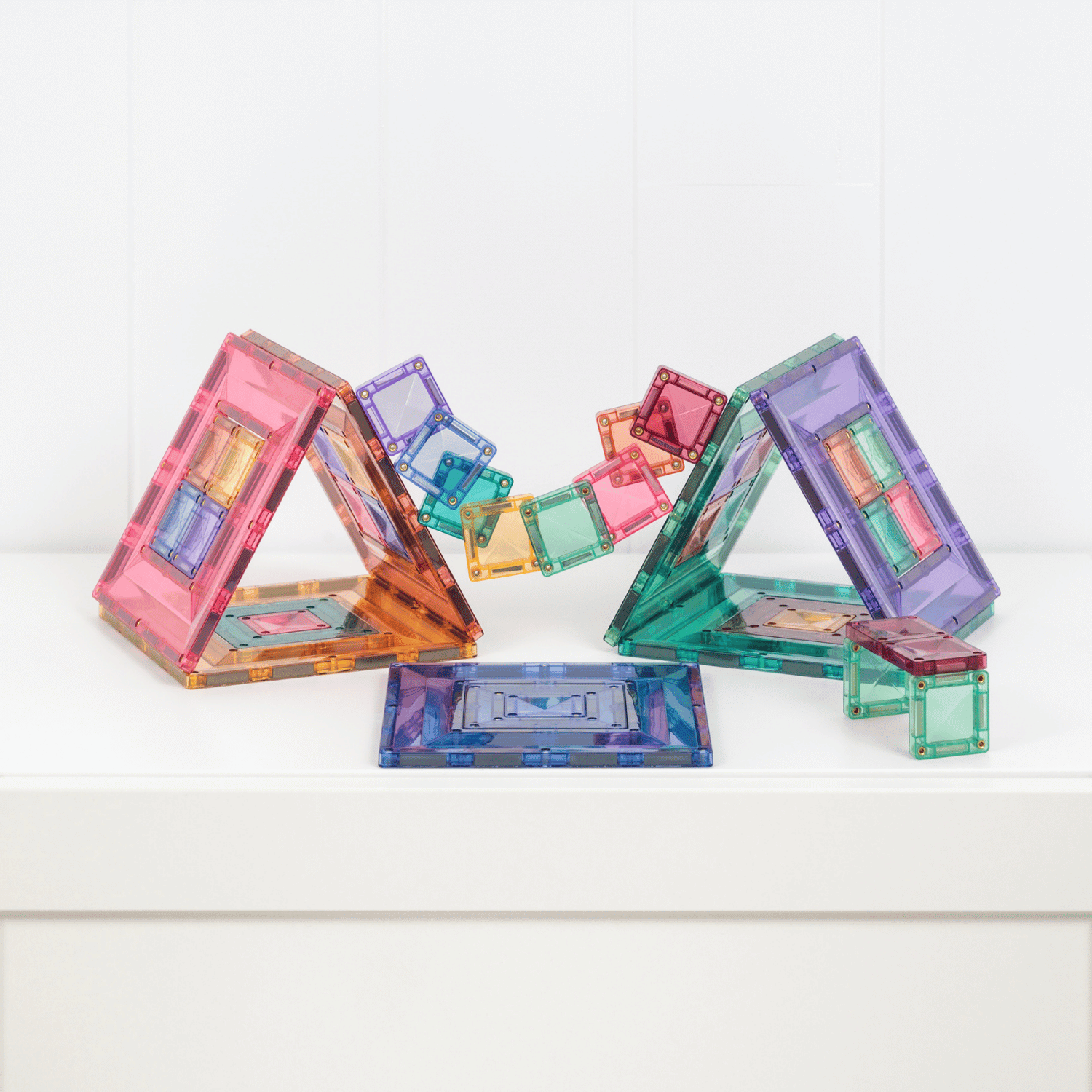 Colorful transparent geometric building blocks on a white surface