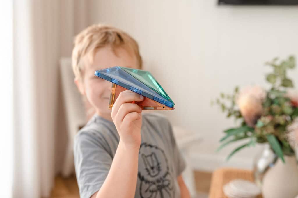 Child holding a smartphone with a blurred face, indoor setting