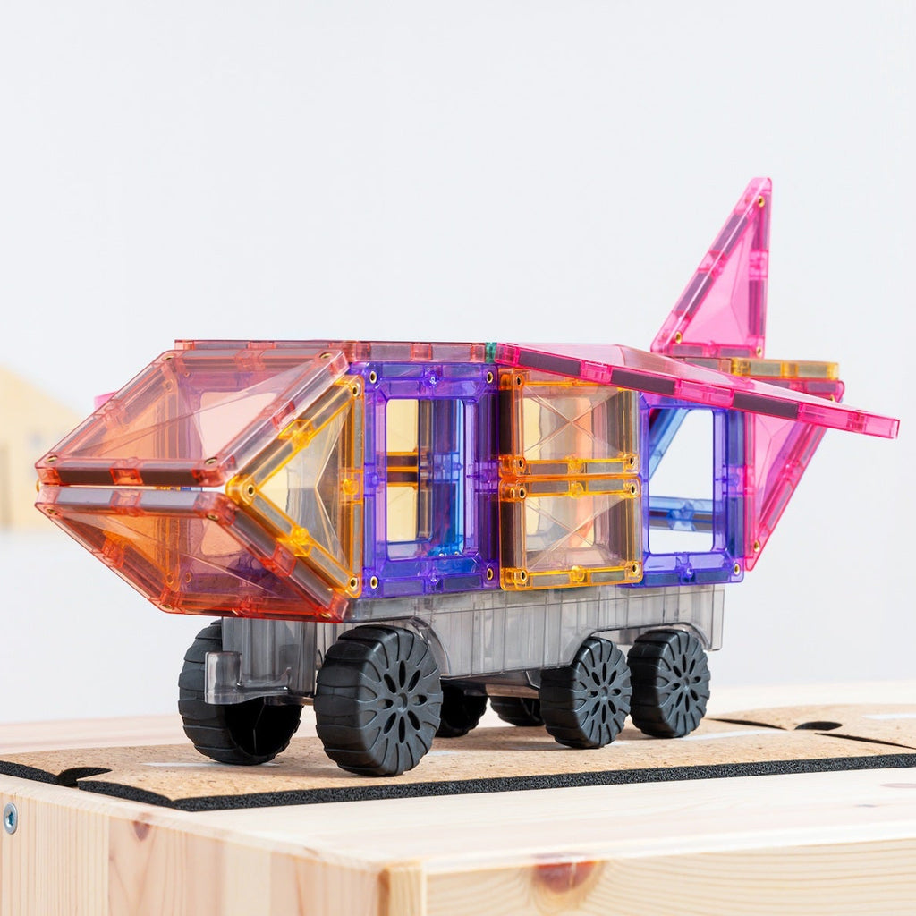 Colorful toy truck on a wooden track with a cityscape in the background