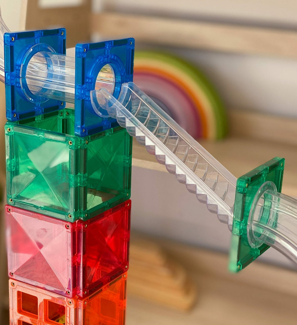 Colorful plastic building blocks with clear tubes on a wooden surface