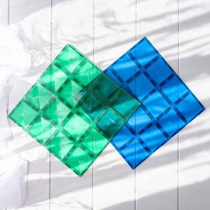 Two green and blue square magnetic base plates on a white background