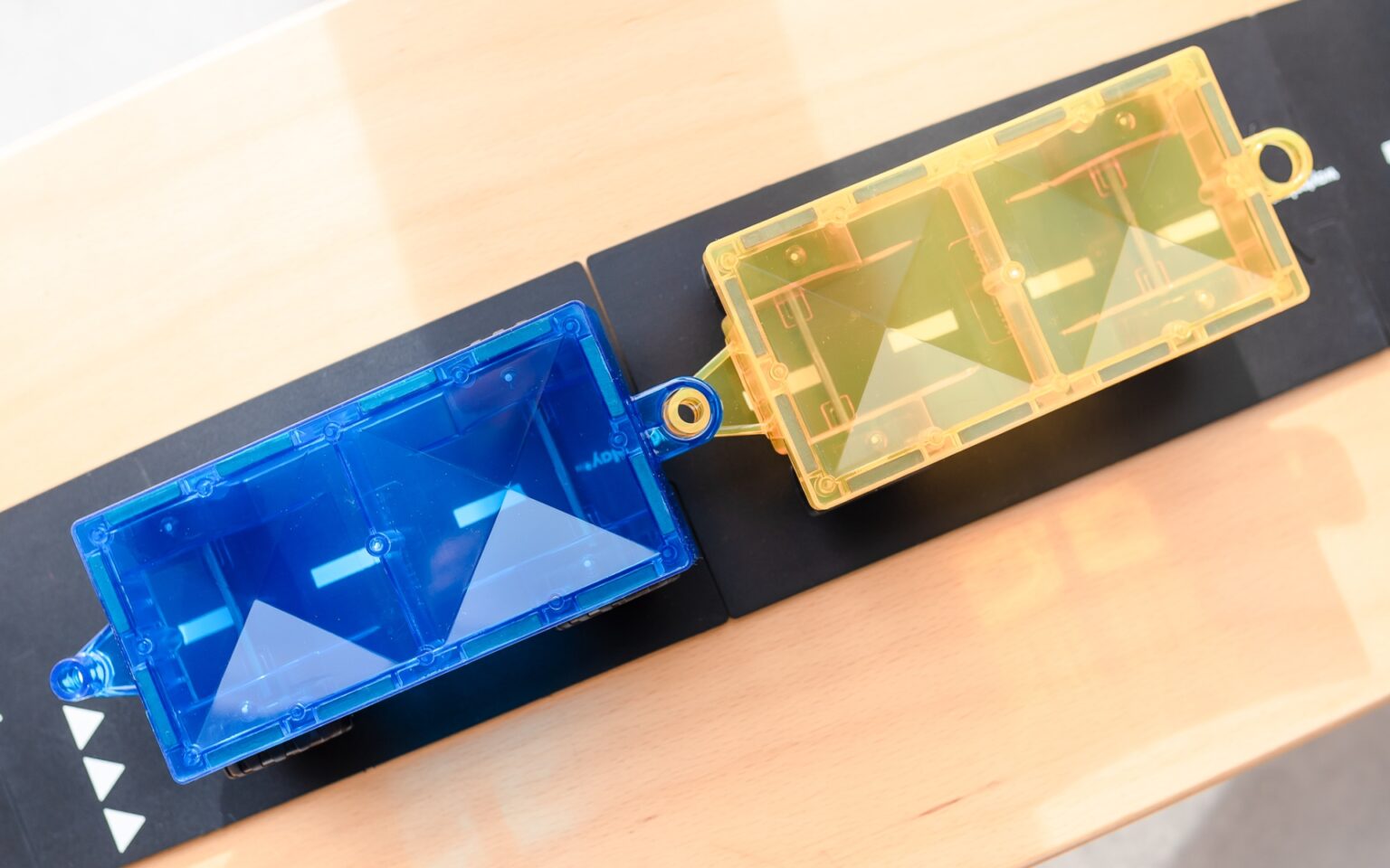 Close-up of blue and yellow plastic components on a black surface