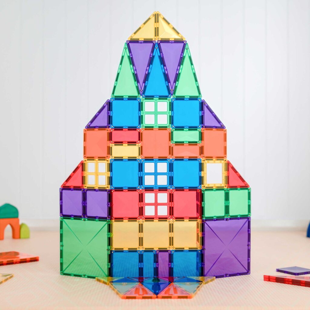 Colorful magnetic building block tower on a light surface with a white background