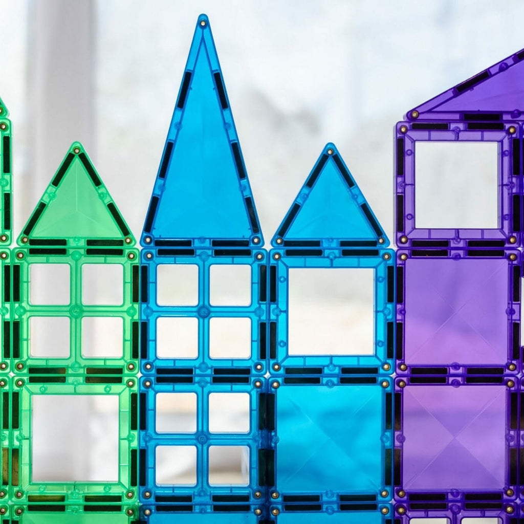 Colorful magnetic building blocks arranged in a row on a light background