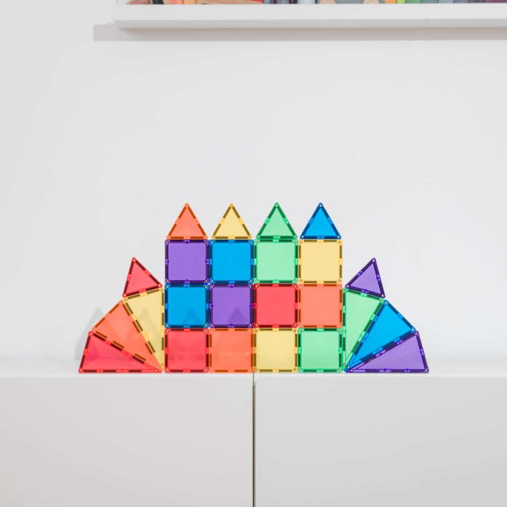 Colorful magnetic building blocks arranged in a castle shape on a white surface.