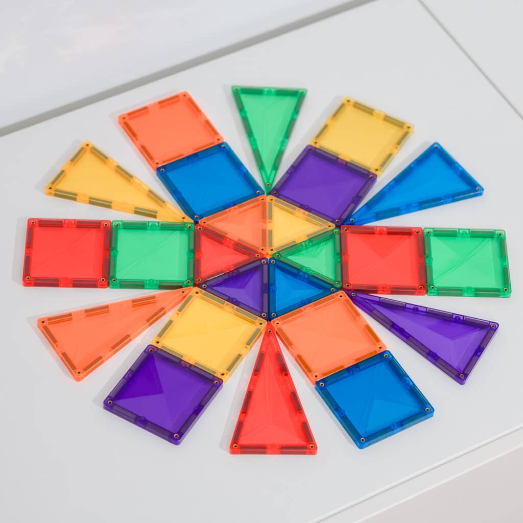 Colorful magnetic building blocks arranged in a circular pattern on a white surface.