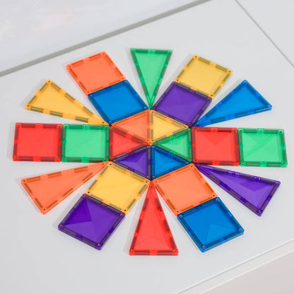 Colorful magnetic building blocks arranged in a circular pattern on a white surface.